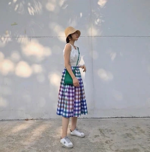 Handmade raffia bucket hat paired with a casual summer outfit and plaid dress