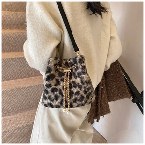 Detail of leopard print plush bucket bag with golden chain and pearl drawstring charms