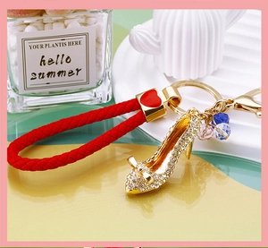 Macro detail of high heel keychain with white crystals and red braided rope