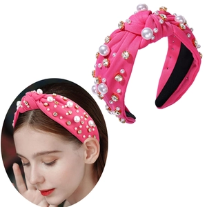 Close-up of pink knotted headband featuring white pearls and shiny rhinestones