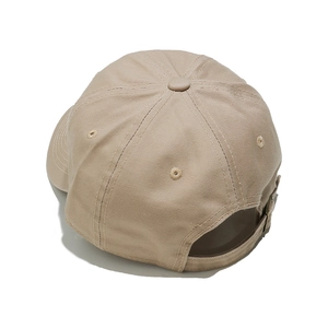 Detail of khaki cotton baseball cap showing back metal adjustment buckle and fabric texture