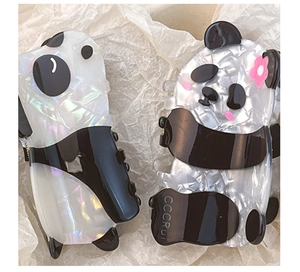 Macro view of panda-shaped hair clips made of marbled black and white acetate with pink floral