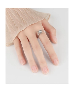 Close-up of a rotating silver sunburst ring with opal stone on a model's finger