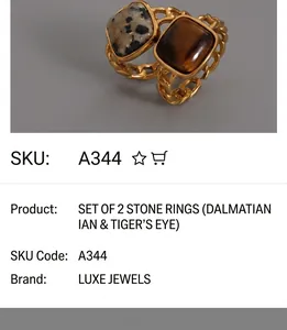 Macro detail of gold chain rings featuring tiger eye and spotted white stone inlays