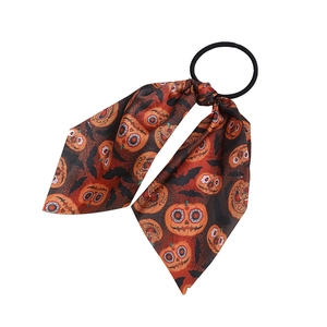 Detail view of Halloween hair scrunchie with orange pumpkin and black bat patterns