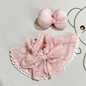 Detailed flat lay of pink checkered plush doll outfit with lace collar and bow accessory