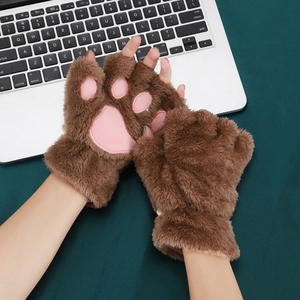 Close-up of brown cat paw plush gloves with pink 3D pads over a laptop keyboard