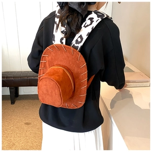 Detail of creative brown suede cowboy hat backpack with cow print shoulder straps
