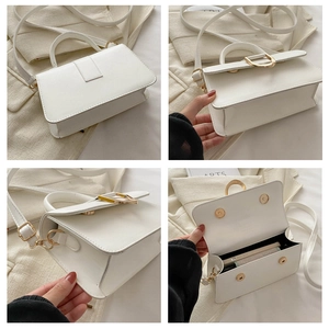 Detail view of white leather handbag featuring gold metal hardware and detachable shoulder strap