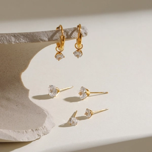Trois paires de boucles d'oreilles dorées en acier inoxydable avec zircons sur pierre
