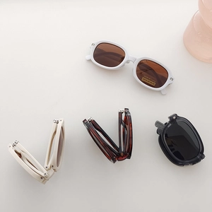 Detailed view of foldable polarized sunglasses in black, white, and tortoise colors
