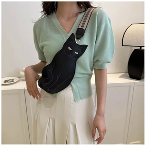 Detail view of black cat-shaped crossbody bag with purple stitching and striped strap