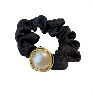 Elegant black scrunchie with high-shine pearl and gold spiral metal ring detail