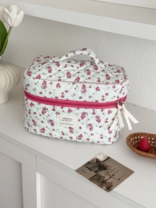 Detailed shot of floral quilted corduroy toiletry bag with vibrant red zipper pull