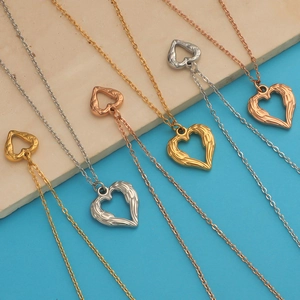 Detail of hollow heart necklaces with wings in gold, silver, and rose gold finishes