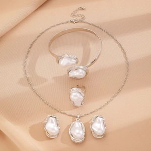 Detailed view of baroque pearl jewelry set on elegant beige silk fabric background