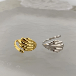 Detail of minimalist shell texture rings in polished gold and silver metal finishes