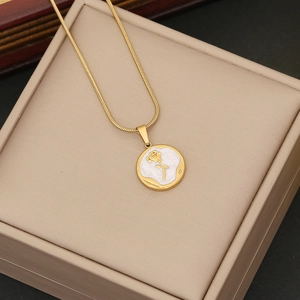 Vintage rose pendant necklace in gold finish with snake chain on beige jewelry box