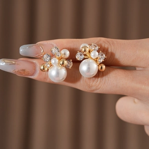 Detailed view of luxury gold-plated flower stud earrings with large white pearls and zircons
