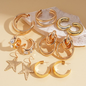 Set of 6 gold-tone geometric earrings featuring crystals, knot designs, and star shapes