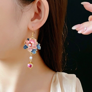 Vintage floral pearl drop earrings with tassels and blue accents on female model