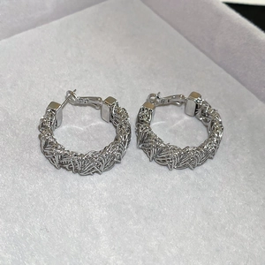 Detail showing the intricate woven mesh texture of silver round hoop earrings