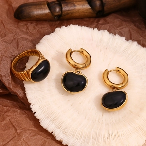 Detailansicht: Herzförmiger Onyx-Ring und Ohrringe mit 18K Vergoldung auf Koralle