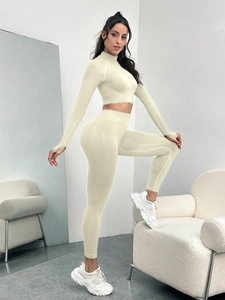 Detail of cable knit yoga set featuring thumb holes on sleeves and high waist leggings
