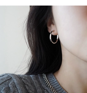 Close-up of minimalist s925 silver hoop earring worn by a model for a stylish look