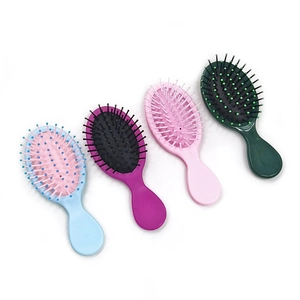 Detail of four colorful mini massage hairbrushes in blue, purple, pink and green