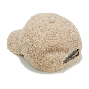 Dettaglio del berretto da baseball in pile sherpa beige con texture soffice e profilo