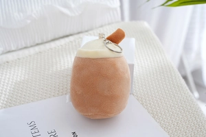 Plush bubble tea keychain with brown cup and soft metal ring on a cozy magazine setting