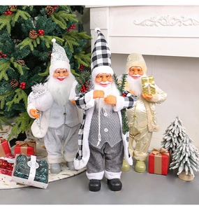 Three Santa Claus dolls in gold, silver, and plaid outfits by a warm Christmas fireplace