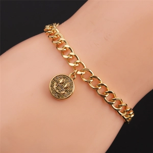 Macro shot of gold Cuban chain bracelet with a sparkling crystal smile face charm