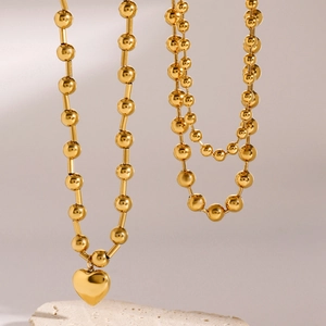 18K gold plated stainless steel beaded heart necklace on a natural stone display