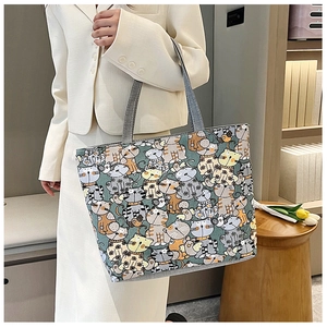 Lifestyle shot of large canvas tote bag with colorful cartoon cat patterns for women