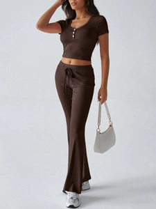 Dettaglio del set due pezzi in maglia marrone scuro con top a maniche corte e scollo a V