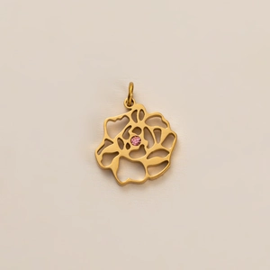 Détail d'un pendentif rose plaqué or avec cristal rose et design en métal évidé