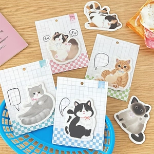 Close-up of adorkable kitten sticky notes in various cat shapes on a wooden desk