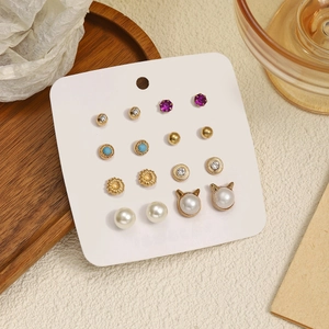 Vue détaillée d'un lot de 8 paires de boucles d'oreilles dorées avec perles et gemmes