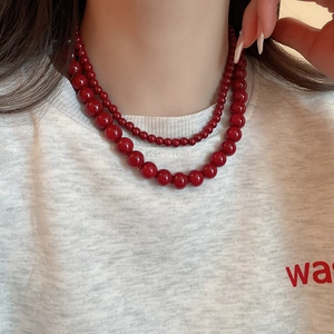 Close-up of double-layer red glass bead necklace on model with gradient bead sizes
