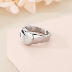 Bague cœur minimaliste en argent sur support rose avec fond floral délicat