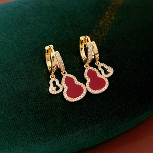 Detail of gold-plated hollow gourd earrings with red crystals and micro-inlaid zircons