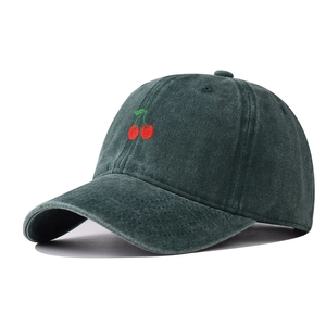 Close-up of vintage washed green baseball cap with cherry embroidery detail