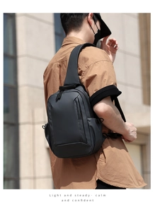 Men's matte black waterproof crossbody bag shown from a side-back view on a model