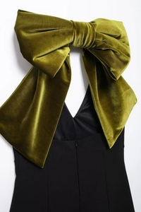 Détail d'un grand nœud en velours vert olive sur le dos d'une robe moulante noire élégante