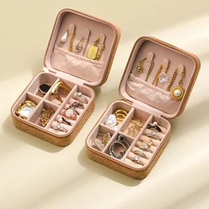 Detail view of portable cork jewelry box with pink velvet lining and organized storage slots