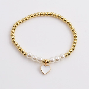 Elastic beaded bracelet featuring gold metal beads, white pearls, and a heart charm