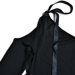 Primer plano de top negro sin mangas con elegante detalle de lazo al cuello en fondo blanco