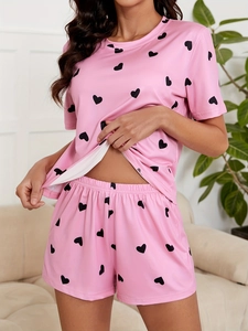 Close-up of pink knit pajamas with heart print, short sleeves and elastic waistband